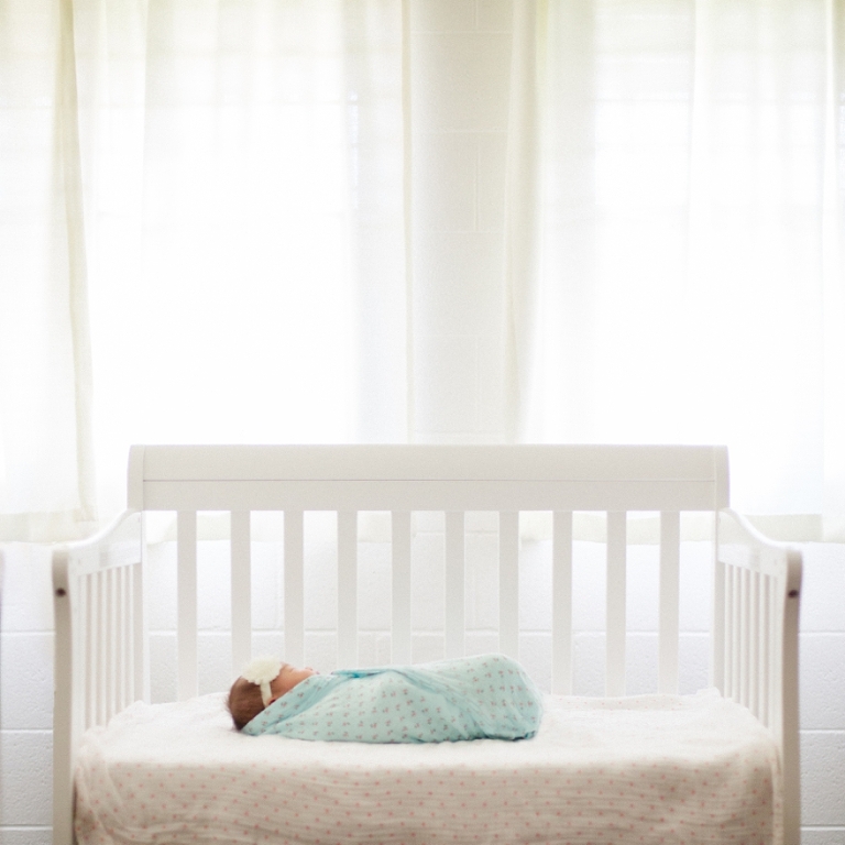 new born baby in white crib